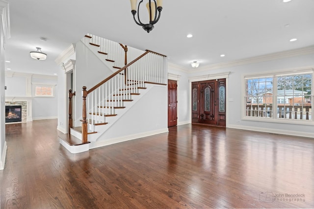 interior space with stairway, a fireplace, ornamental molding, and wood finished floors