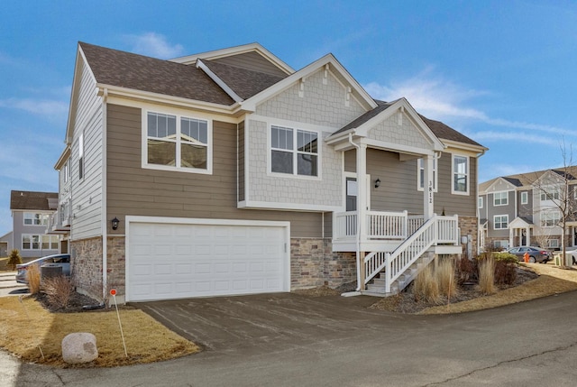 view of front of home with aphalt driveway, stone siding, and a garage