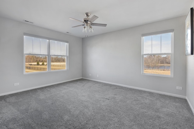 unfurnished room featuring visible vents, baseboards, ceiling fan, and carpet floors