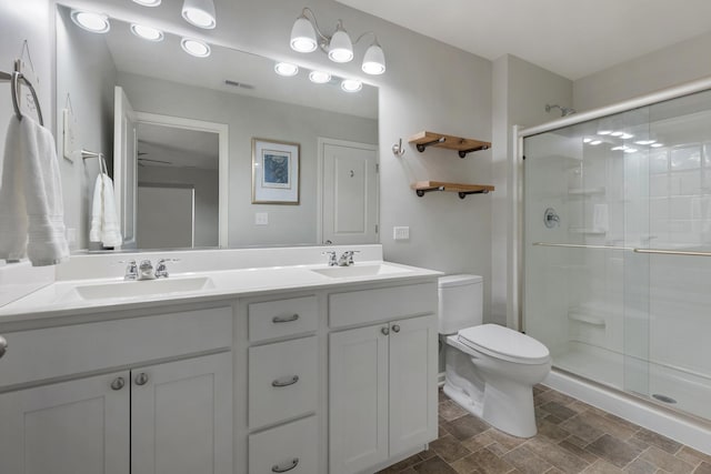 bathroom featuring a sink, toilet, and a stall shower