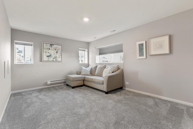 carpeted living room featuring baseboard heating, visible vents, baseboards, and a wealth of natural light