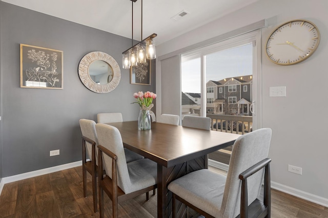 dining space with visible vents, baseboards, and wood finished floors