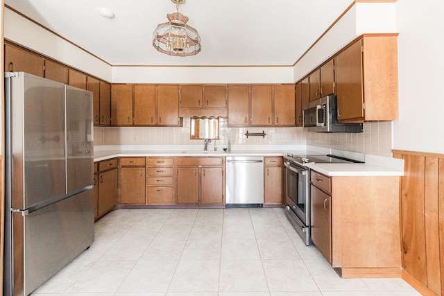 kitchen featuring decorative backsplash, brown cabinets, stainless steel appliances, light countertops, and a sink