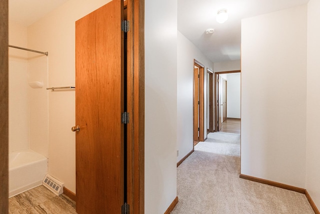 corridor with carpet, baseboards, and visible vents