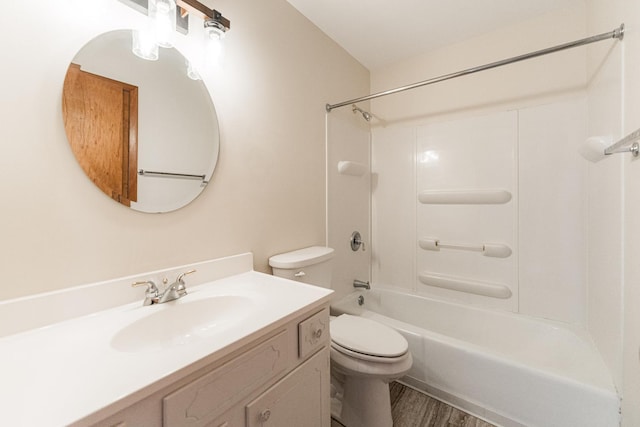 bathroom with washtub / shower combination, wood finished floors, vanity, and toilet