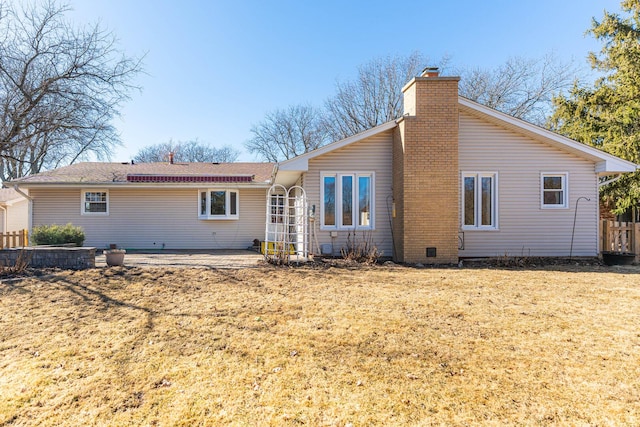 back of property featuring a yard, a patio area, fence, and a chimney