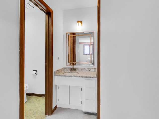 bathroom with toilet, baseboards, and vanity