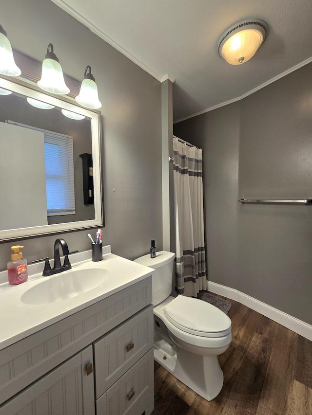 full bath featuring baseboards, toilet, wood finished floors, crown molding, and vanity