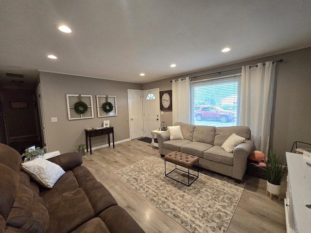 living area featuring baseboards, light wood finished floors, visible vents, and recessed lighting