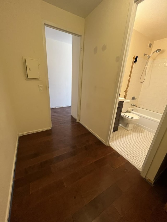 corridor with dark wood-style floors and baseboards