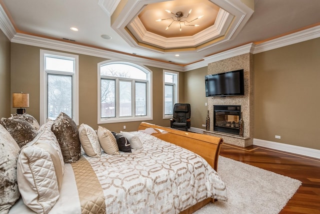 bedroom with multiple windows, a large fireplace, baseboards, and wood finished floors