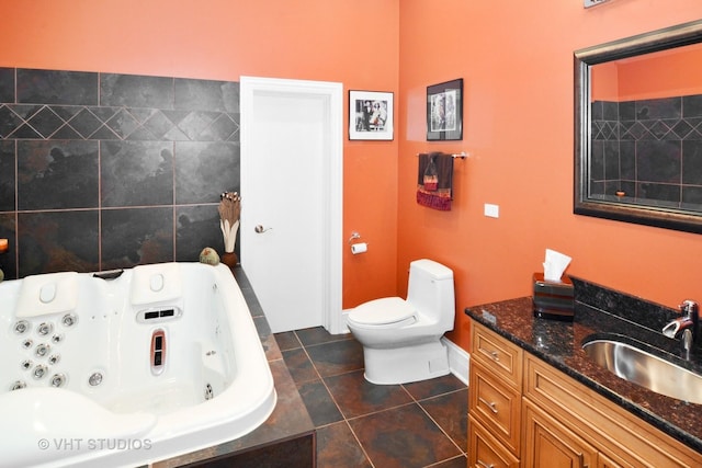 bathroom featuring vanity, toilet, a whirlpool tub, and tile patterned flooring