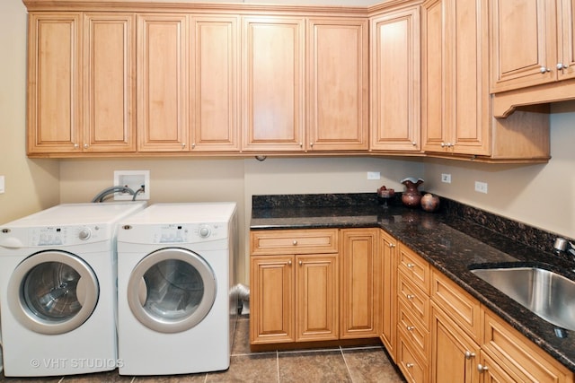 washroom featuring cabinet space, washer and dryer, and a sink