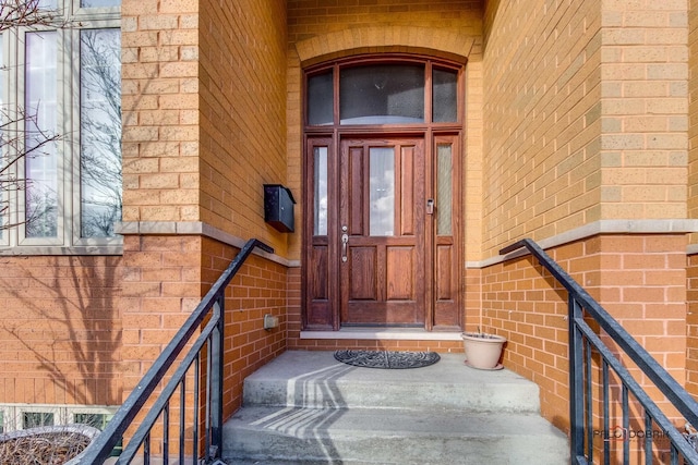 doorway to property featuring brick siding