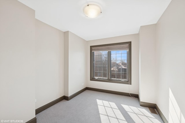 unfurnished room with light colored carpet, visible vents, and baseboards