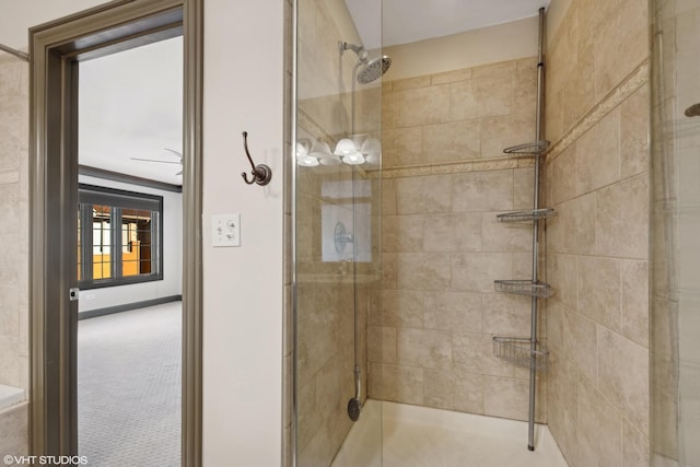 bathroom with tiled shower and baseboards