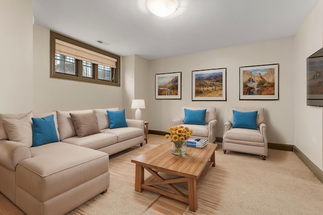 living room with light carpet, visible vents, and baseboards