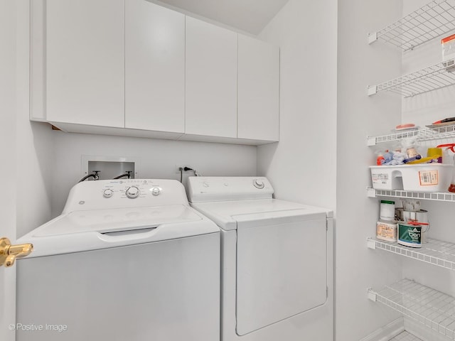 clothes washing area with independent washer and dryer and cabinet space