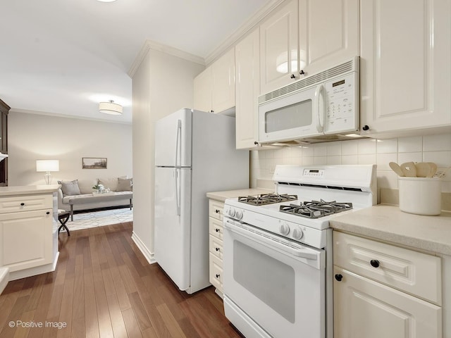 kitchen with white appliances, light countertops, crown molding, and white cabinetry