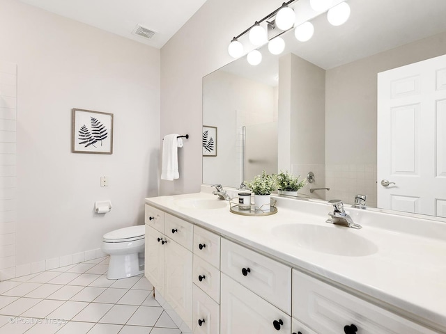 bathroom featuring toilet, visible vents, a sink, and tile patterned floors