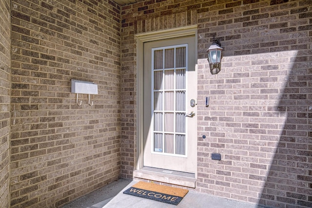 view of exterior entry featuring brick siding