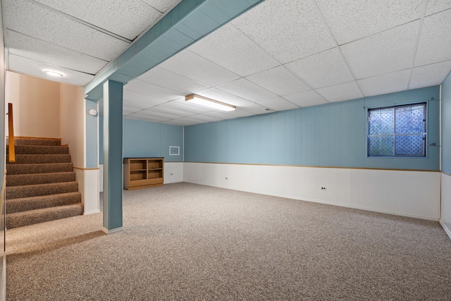 finished basement with carpet floors, a drop ceiling, visible vents, and stairs