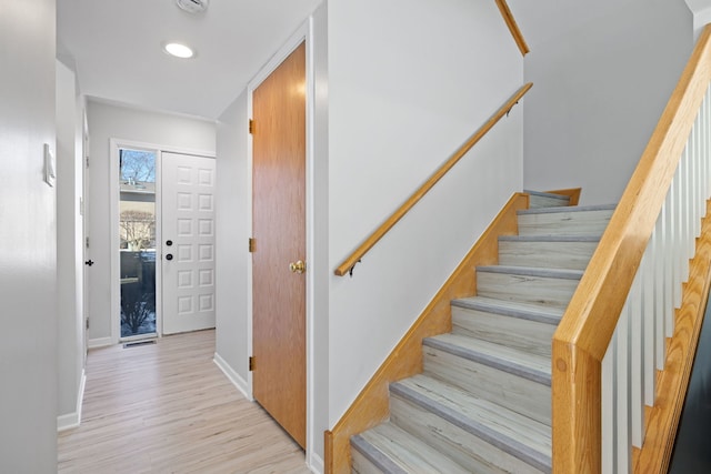 stairway featuring recessed lighting, wood finished floors, and baseboards