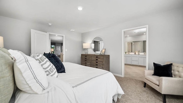 bedroom featuring recessed lighting, light carpet, baseboards, and ensuite bathroom