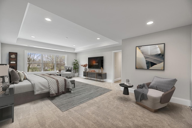 carpeted bedroom with recessed lighting, a raised ceiling, and baseboards