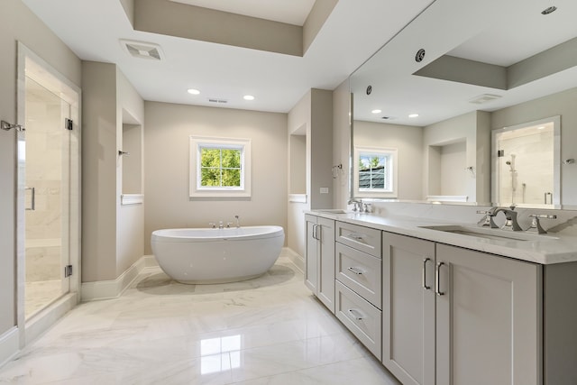 full bath with a freestanding tub, a sink, baseboards, a shower stall, and double vanity