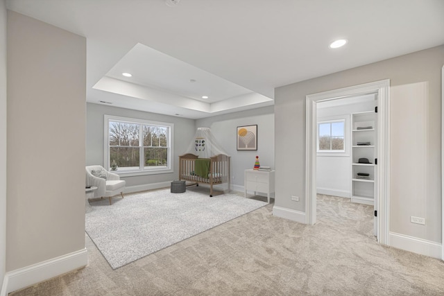 living area with a tray ceiling, carpet, a wealth of natural light, and baseboards