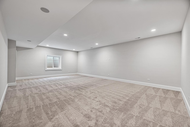 spare room with light carpet, recessed lighting, and baseboards