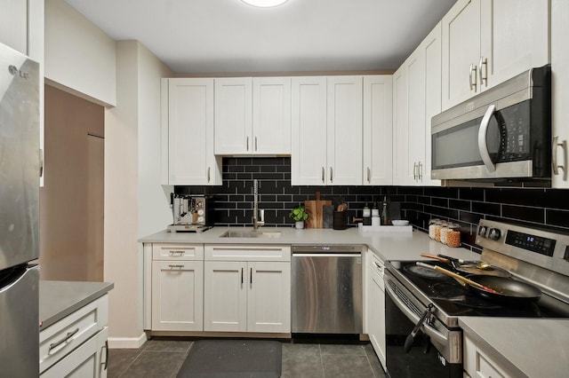 kitchen featuring stainless steel appliances, a sink, light countertops, and white cabinets