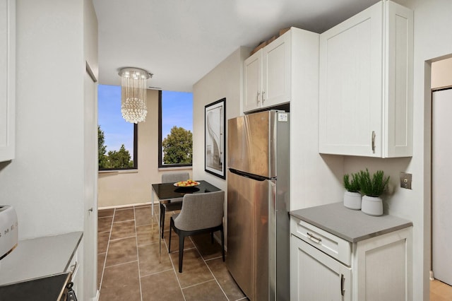 kitchen with hanging light fixtures, white cabinetry, a chandelier, and freestanding refrigerator