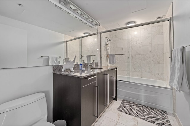 bathroom featuring enclosed tub / shower combo, vanity, and toilet