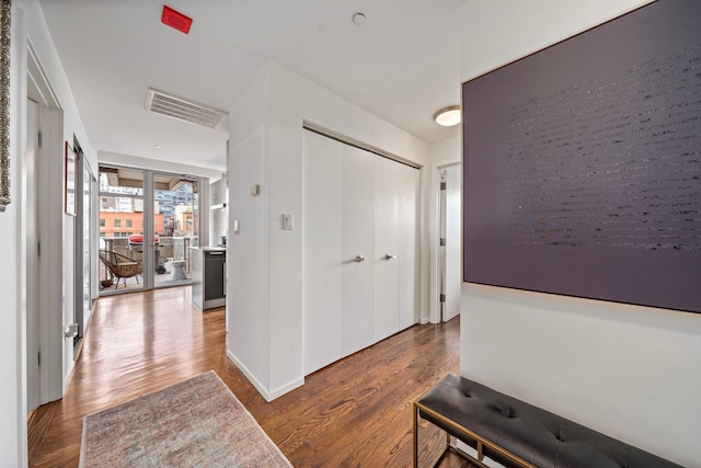 corridor featuring dark wood-style flooring and visible vents