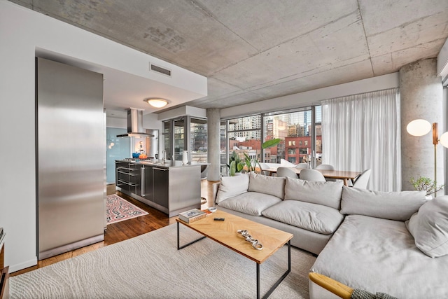 living area with a view of city, wood finished floors, and visible vents