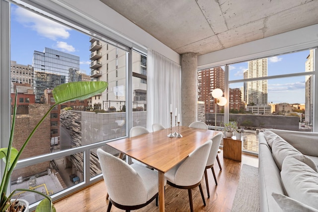 dining space featuring a view of city and wood finished floors