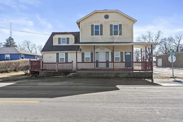 view of front of home with a porch and a shingled roof