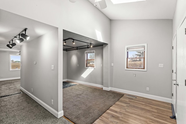 entrance foyer featuring baseboards, ceiling fan, visible vents, and wood finished floors