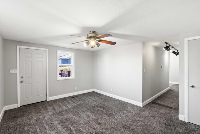 spare room with carpet flooring, a ceiling fan, and baseboards