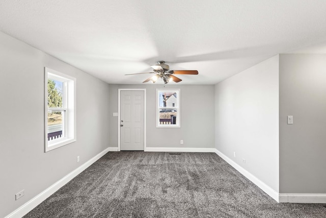 interior space featuring a textured ceiling, a ceiling fan, and baseboards