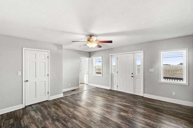 entryway with ceiling fan, a textured ceiling, baseboards, and wood finished floors