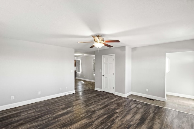 spare room with ceiling fan, a textured ceiling, wood finished floors, visible vents, and baseboards