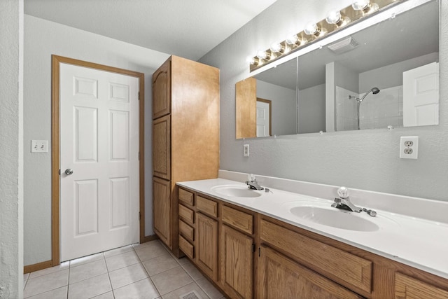 bathroom featuring double vanity, visible vents, a sink, and tile patterned floors