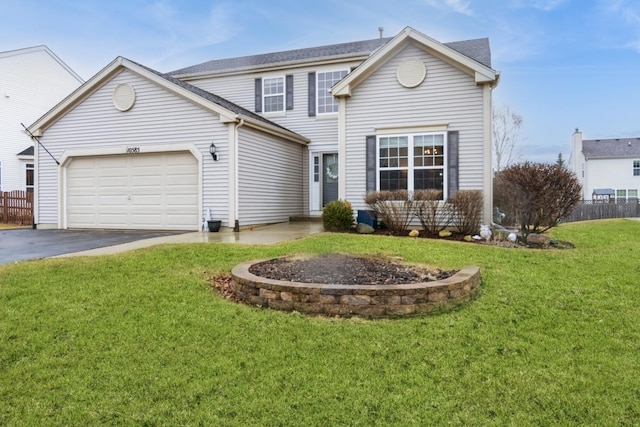 traditional-style home featuring a garage, driveway, fence, and a front lawn