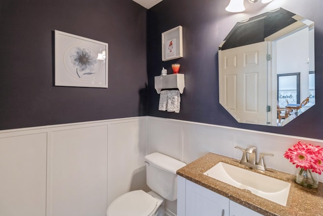 bathroom featuring wainscoting, vanity, and toilet