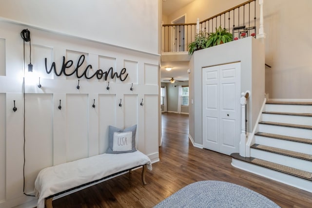 mudroom with baseboards, a high ceiling, and wood finished floors