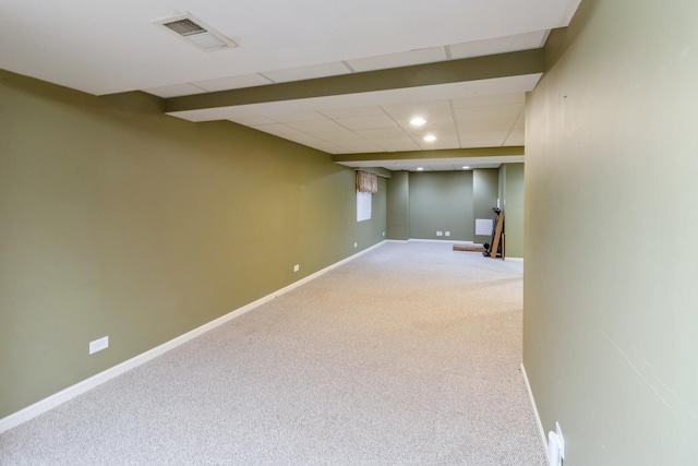 finished basement featuring a paneled ceiling, baseboards, visible vents, and carpet flooring