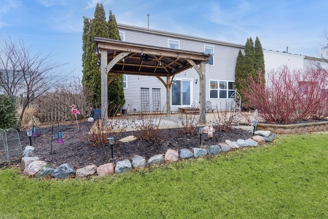 rear view of property featuring a patio area, a lawn, and a gazebo